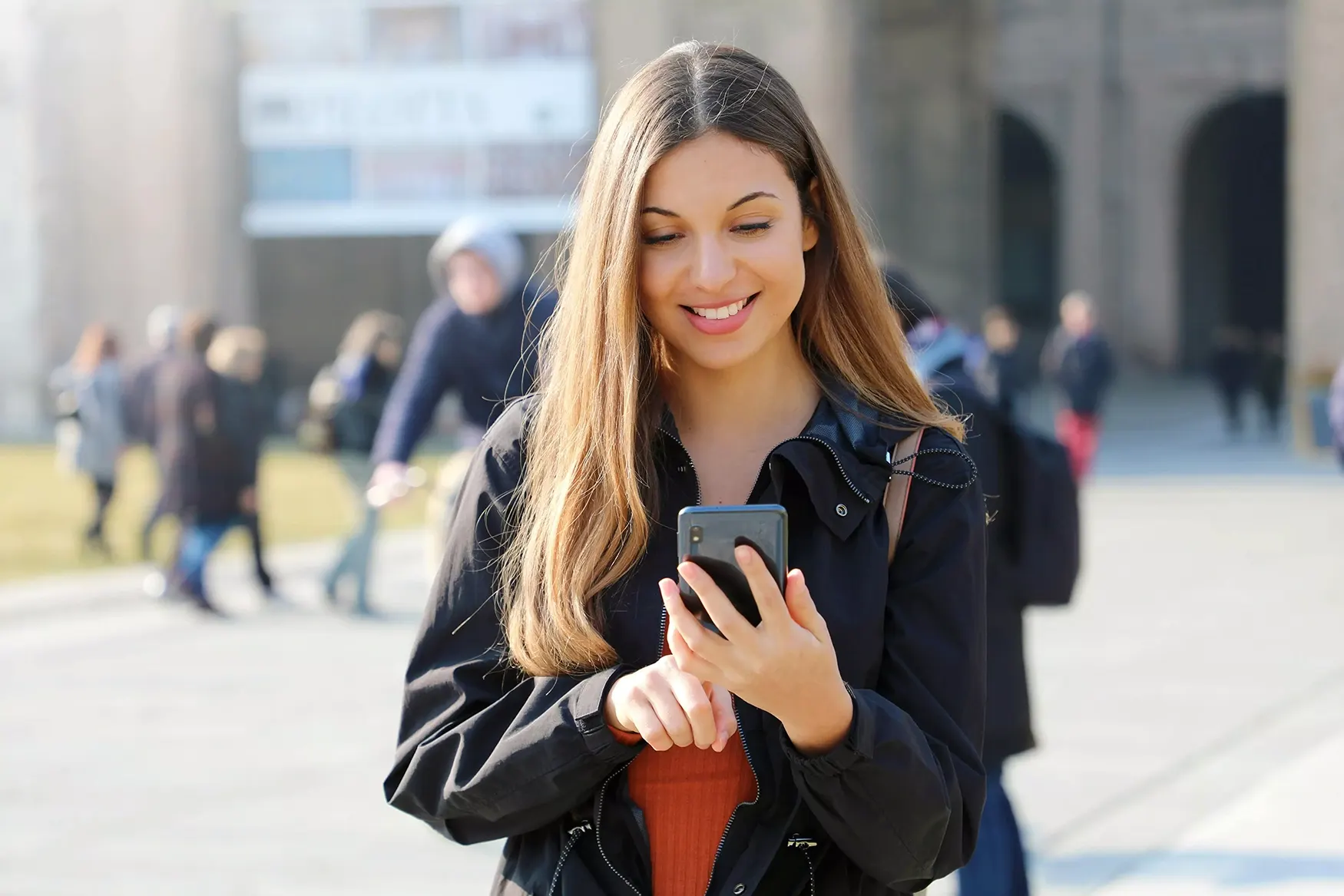 young woman looking on phone in city