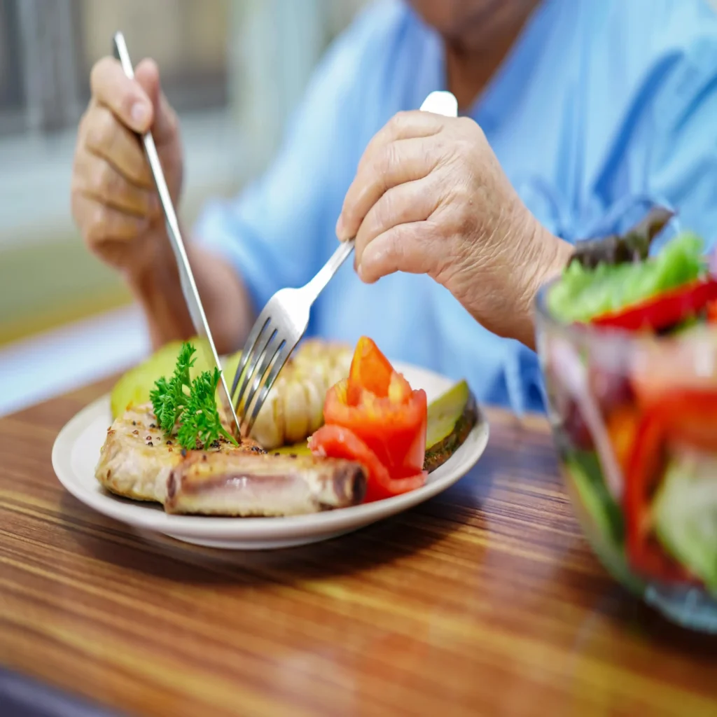old patient cutting food on plate